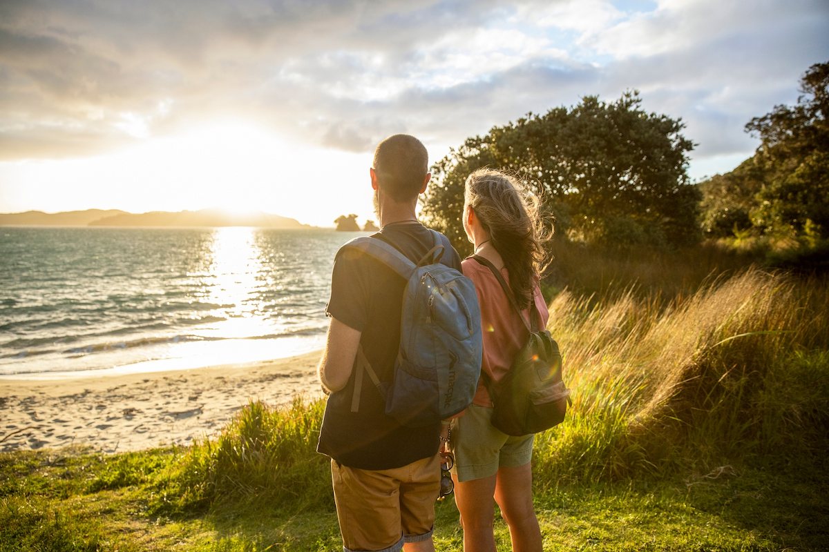Photograph of a man and a woman standing and looking at the waters at Urupukapuka Island, New Zealand